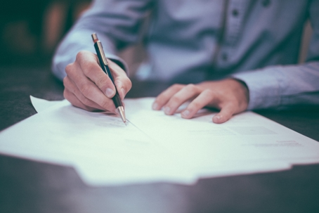 Person signing small stack of papers